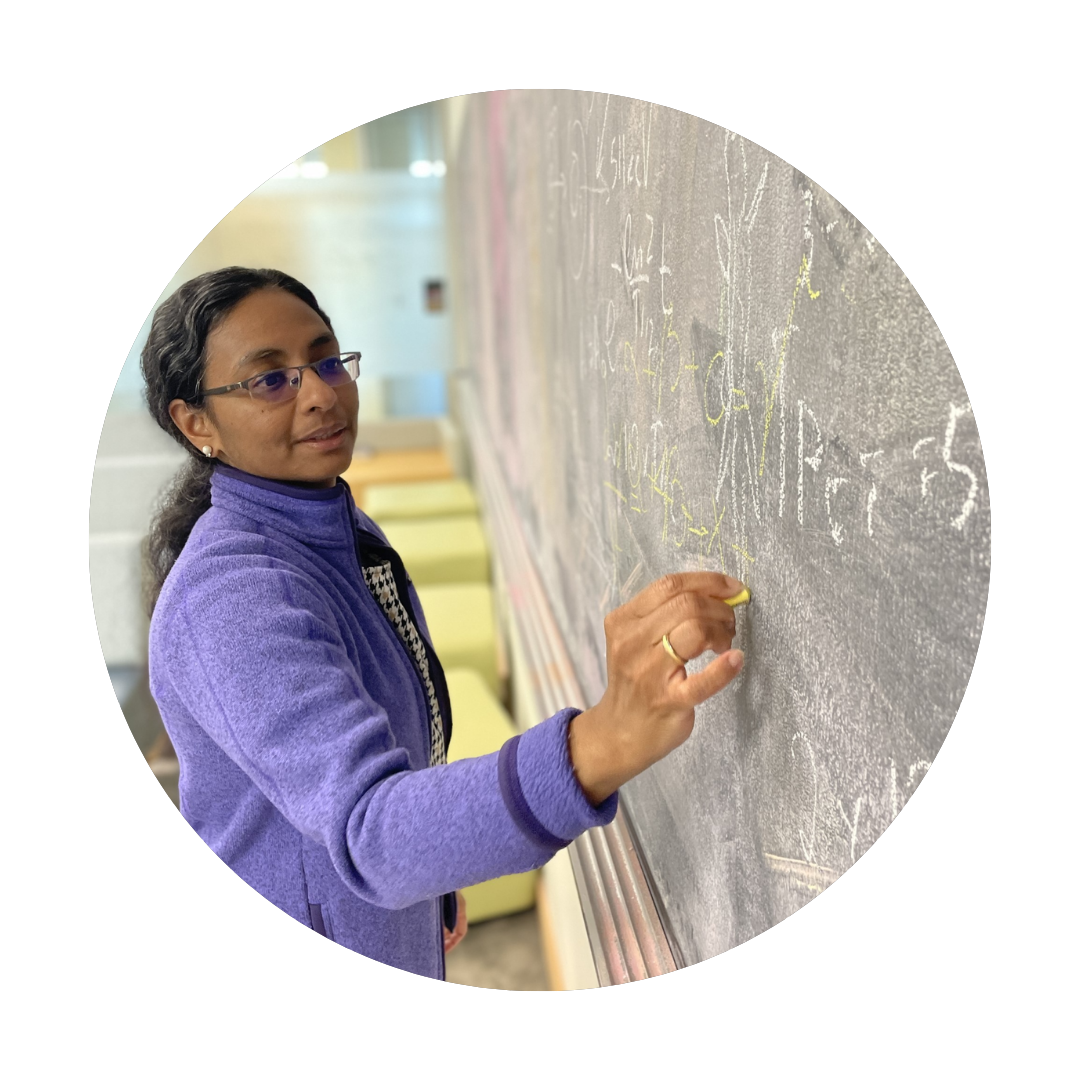 Photo of Sandhya Prabhakaran writing on a chalkboard
